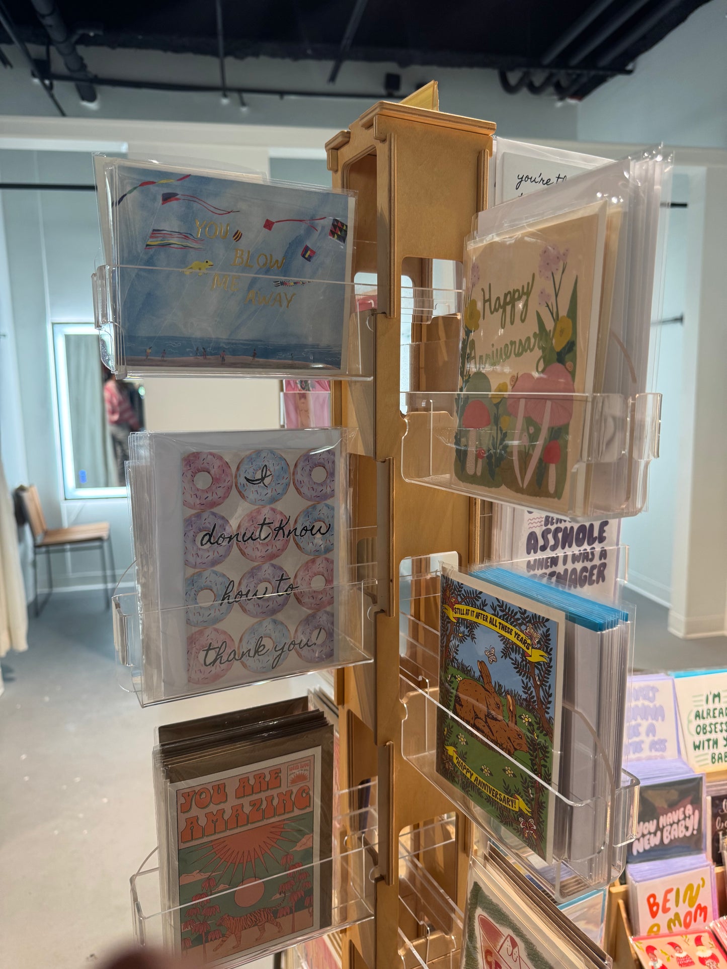 Display of greeting cards in a store with various designs. card spinner at e blackhurst king street