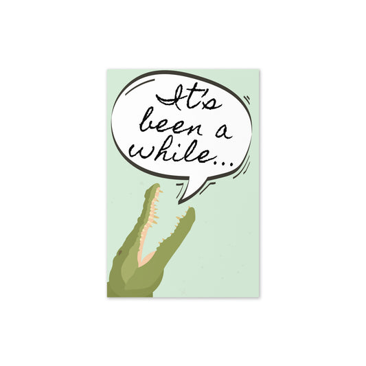 Card with a crocodile and a speech bubble saying 'It's been a while...' on a light green background.