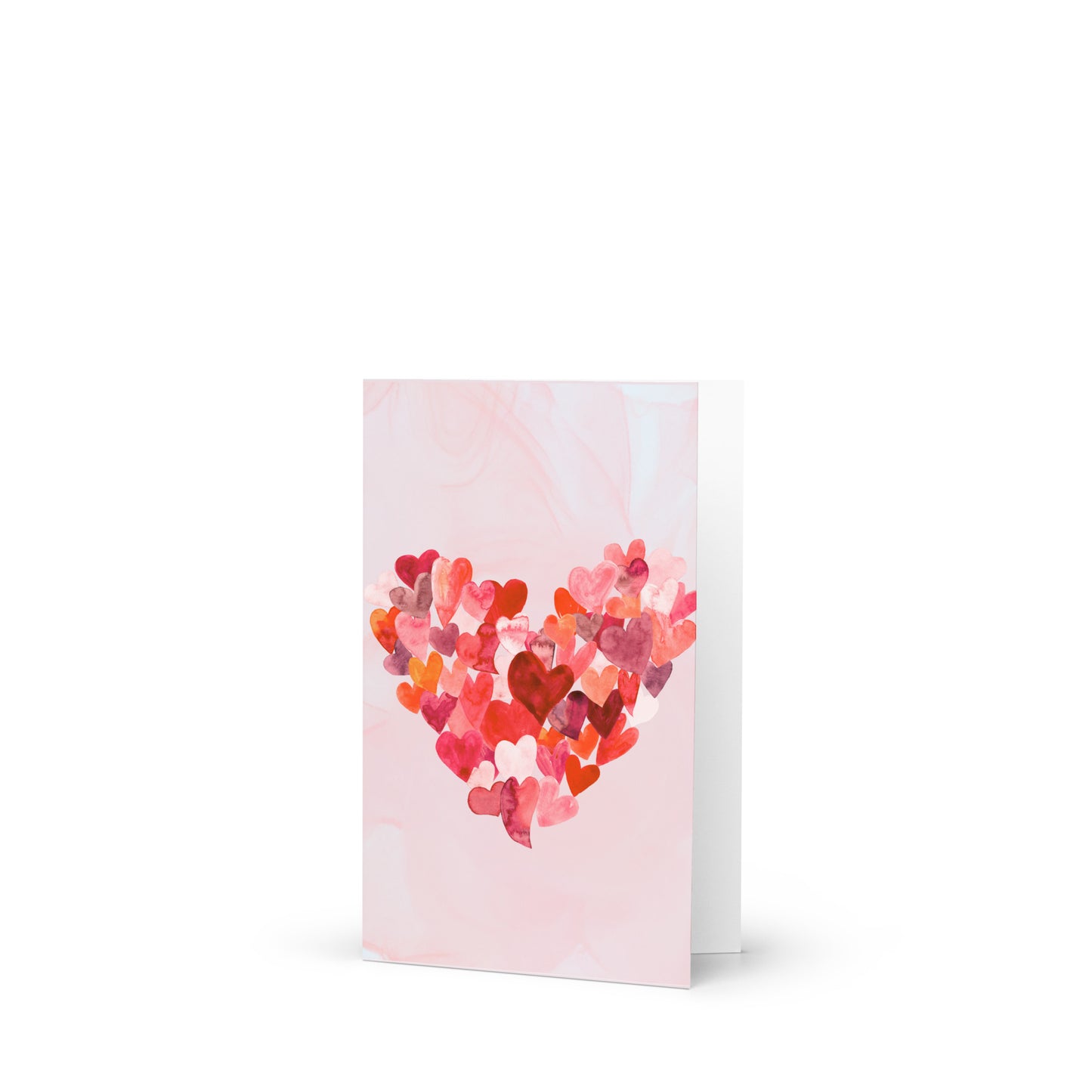 Greeting card with a heart design made of smaller hearts in various colors on a light pink background.