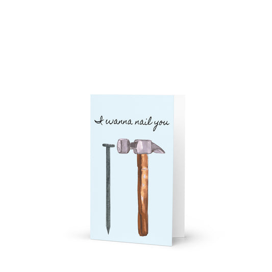 Greeting card with a hammer and nail illustration and text 'I wanna nail you' on a light blue background.