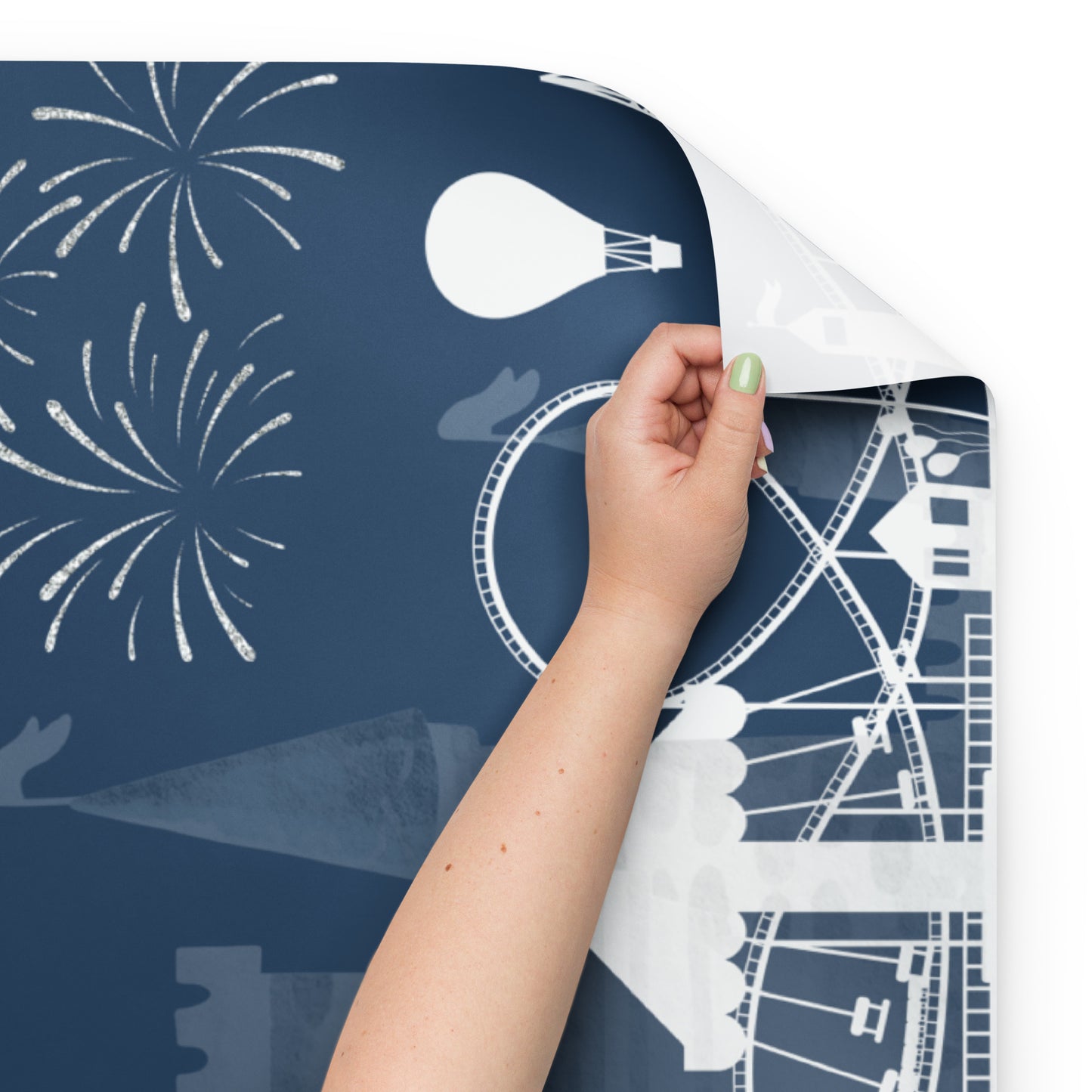 Hand peeling a sheet of paper with white designs from a blue background