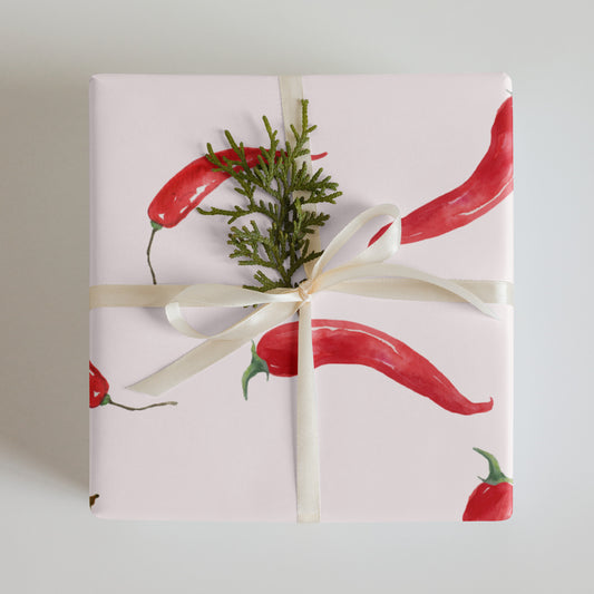 Gift wrapped in paper with red chili pepper design on a light background