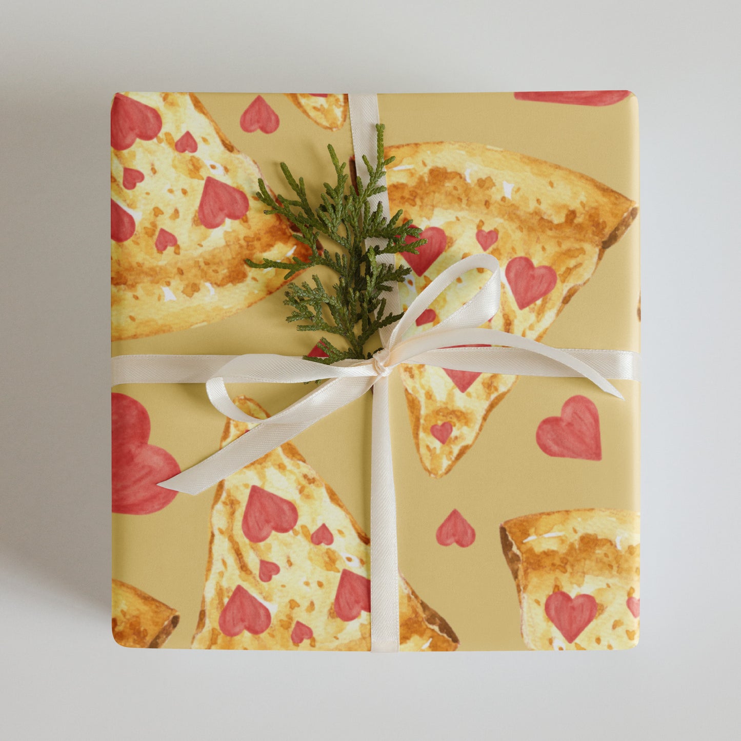 Gift box wrapped with pizza-themed paper featuring heart patterns on a plain background