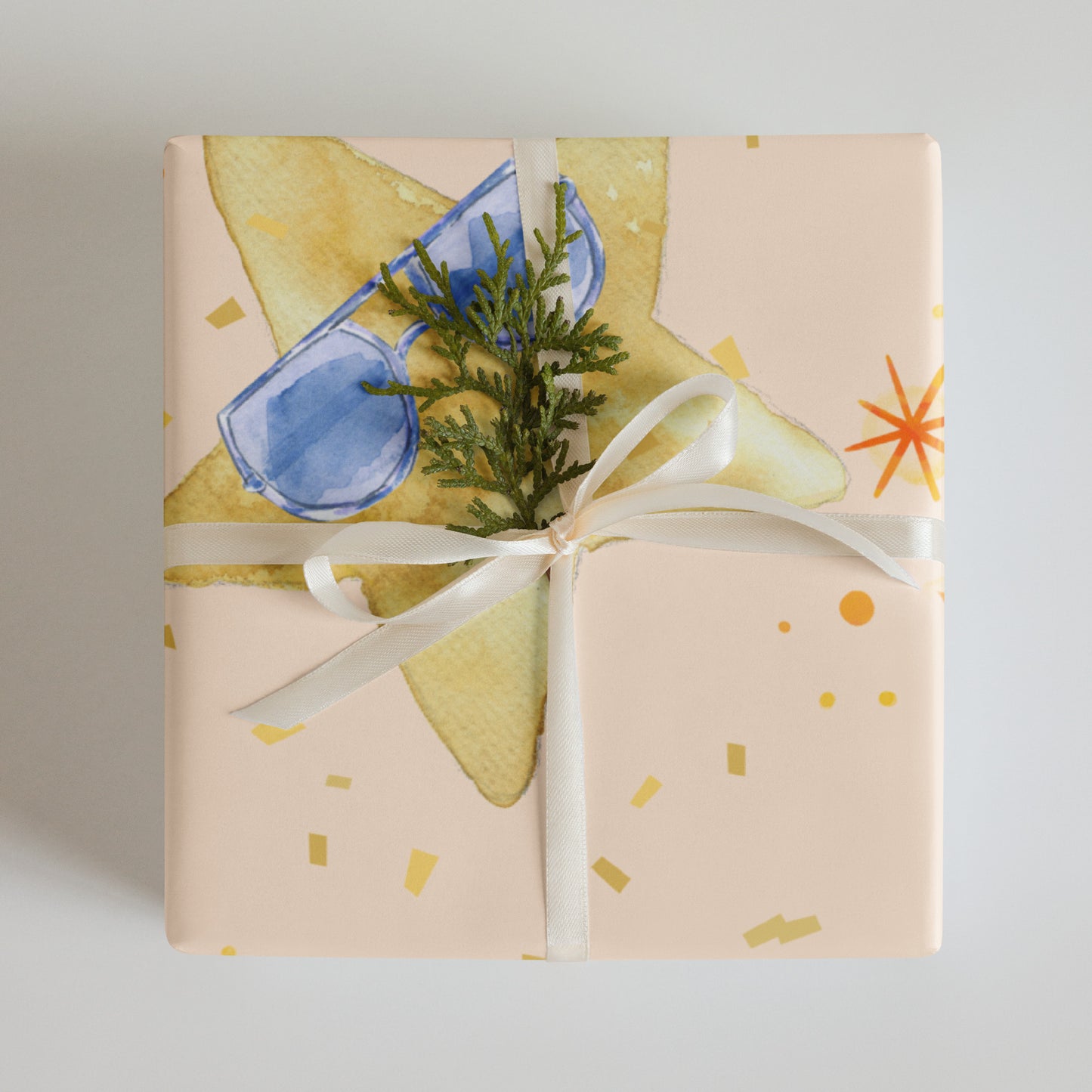 Gift wrapped in paper with sunglasses and a plant, tied with a white ribbon.