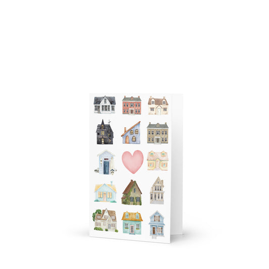 Greeting card with miniature house illustrations and a pink heart on a white background