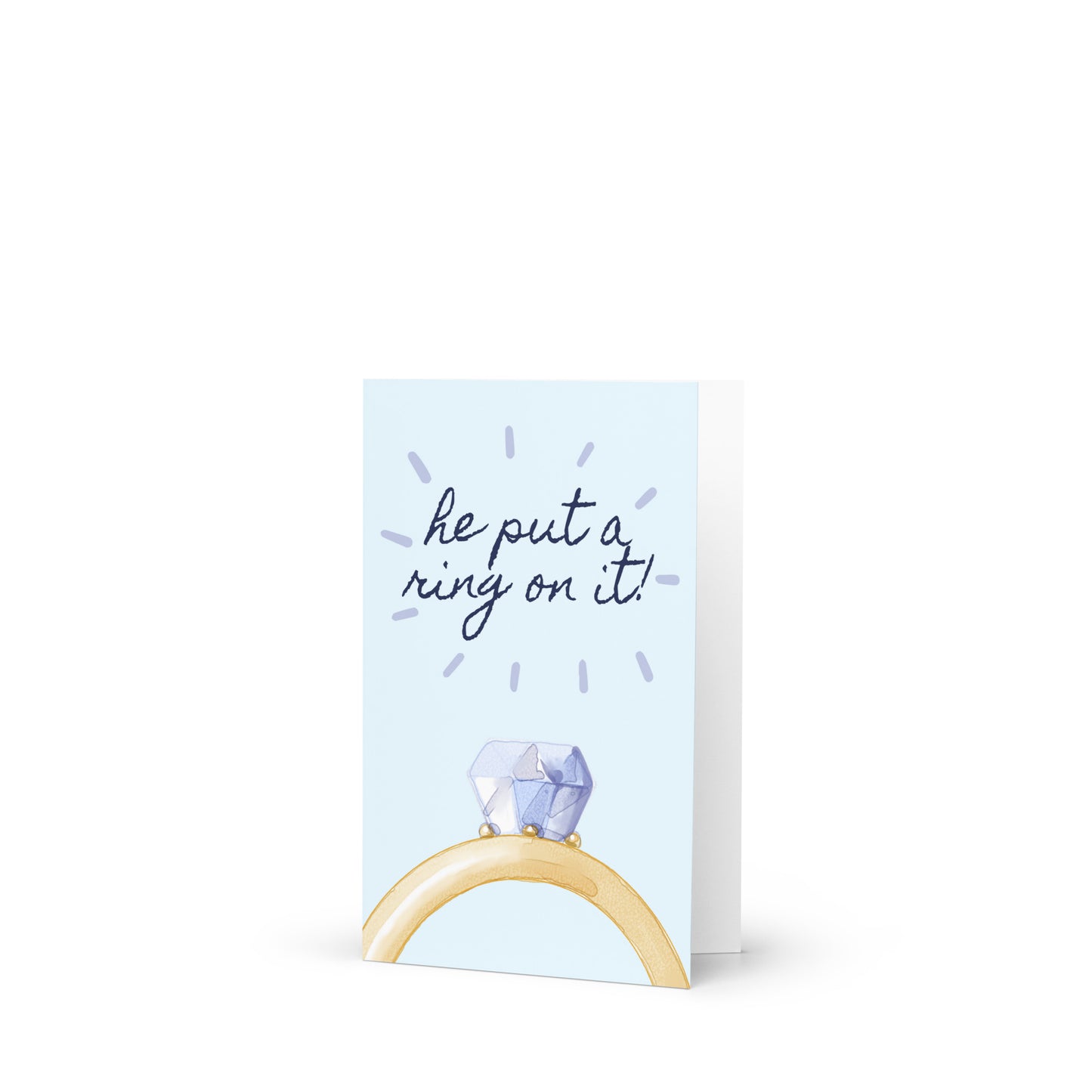Greeting card with a ring holder and 'he put a ring on it!' text on a light blue background