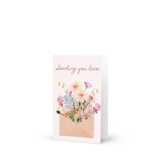 Greeting card with floral design and text 'sending you love' on a white background
