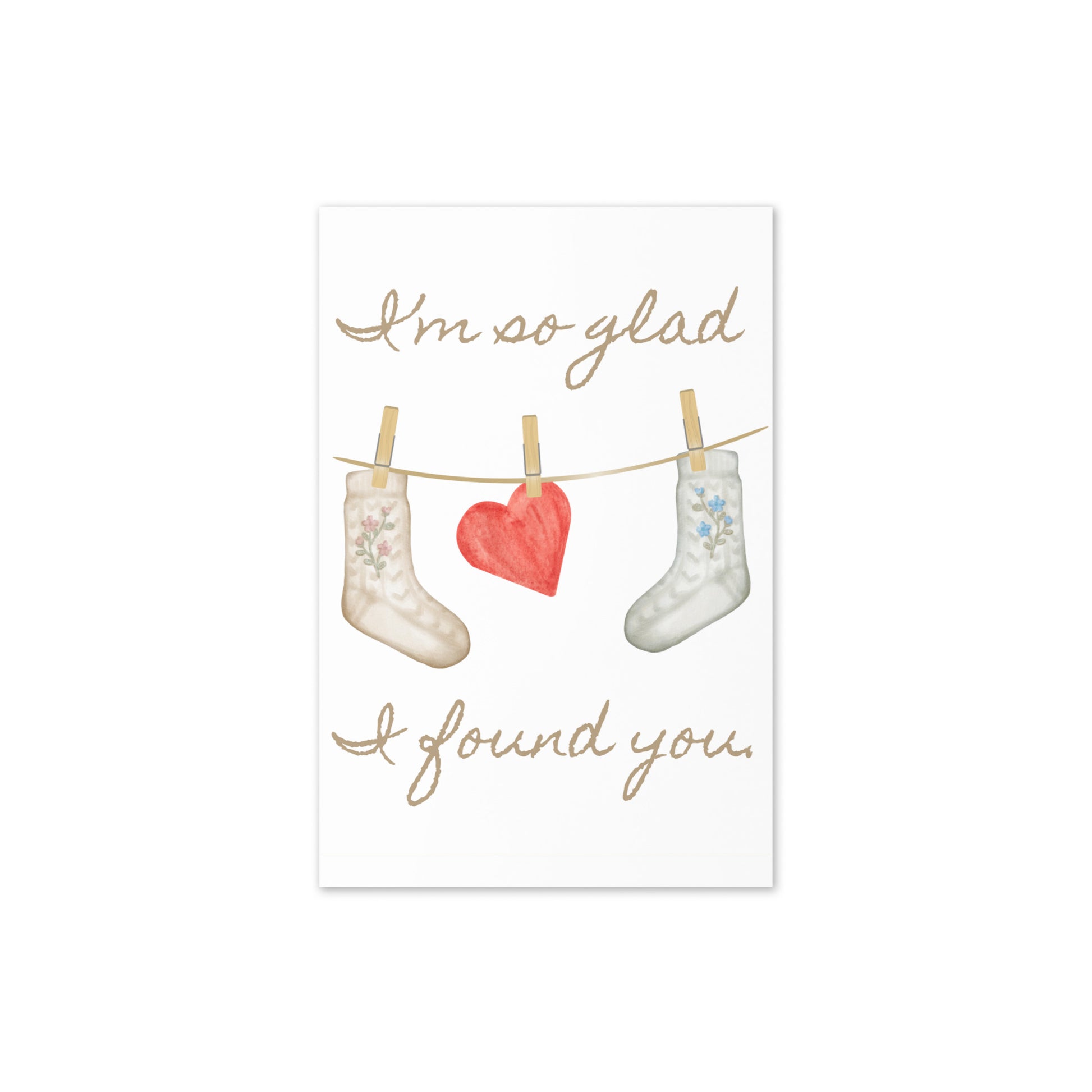 Card with floral socks and a heart on a clothesline with text 'I'm so glad I found you' on a white background.