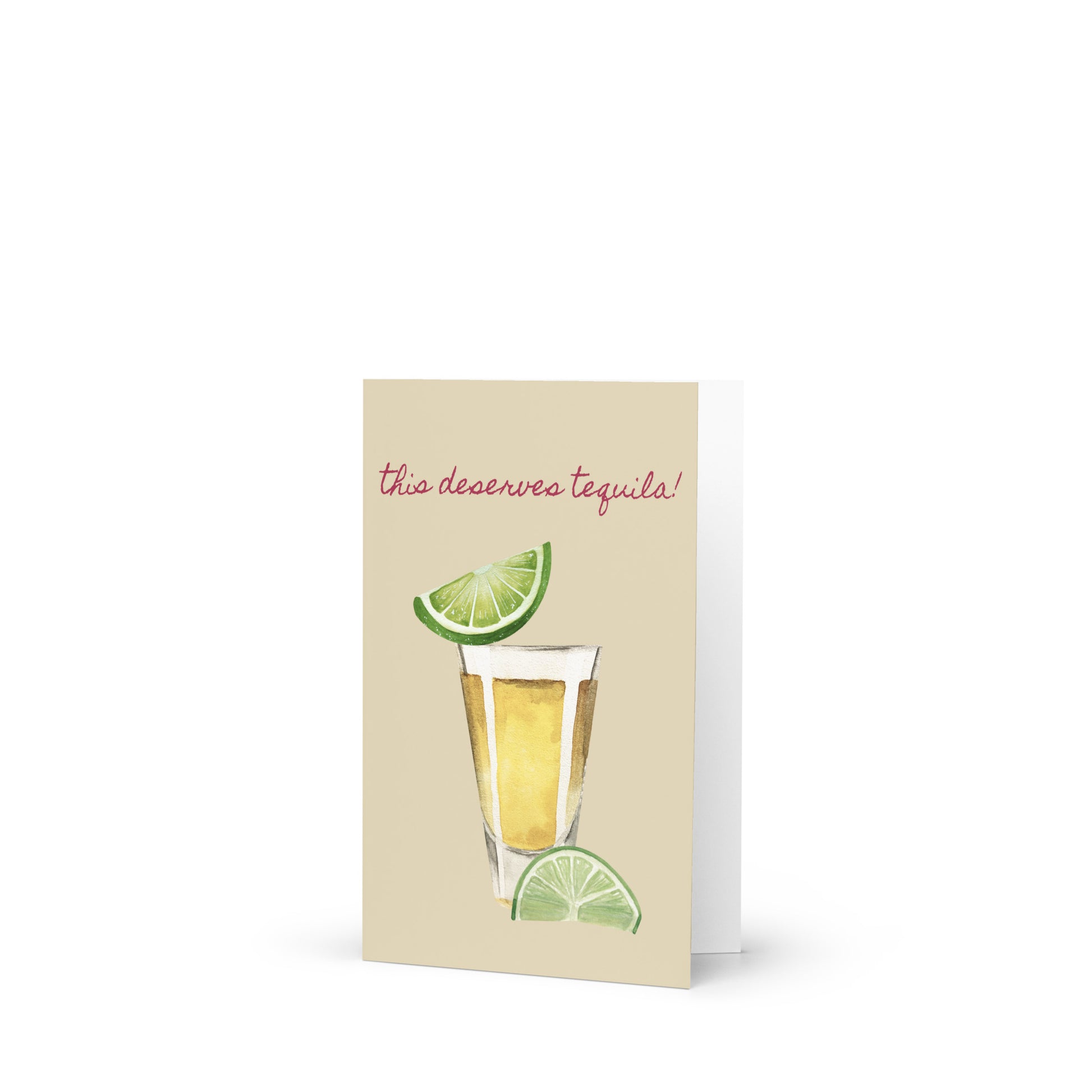 Greeting card with tequila glass and lime garnish on a beige background
