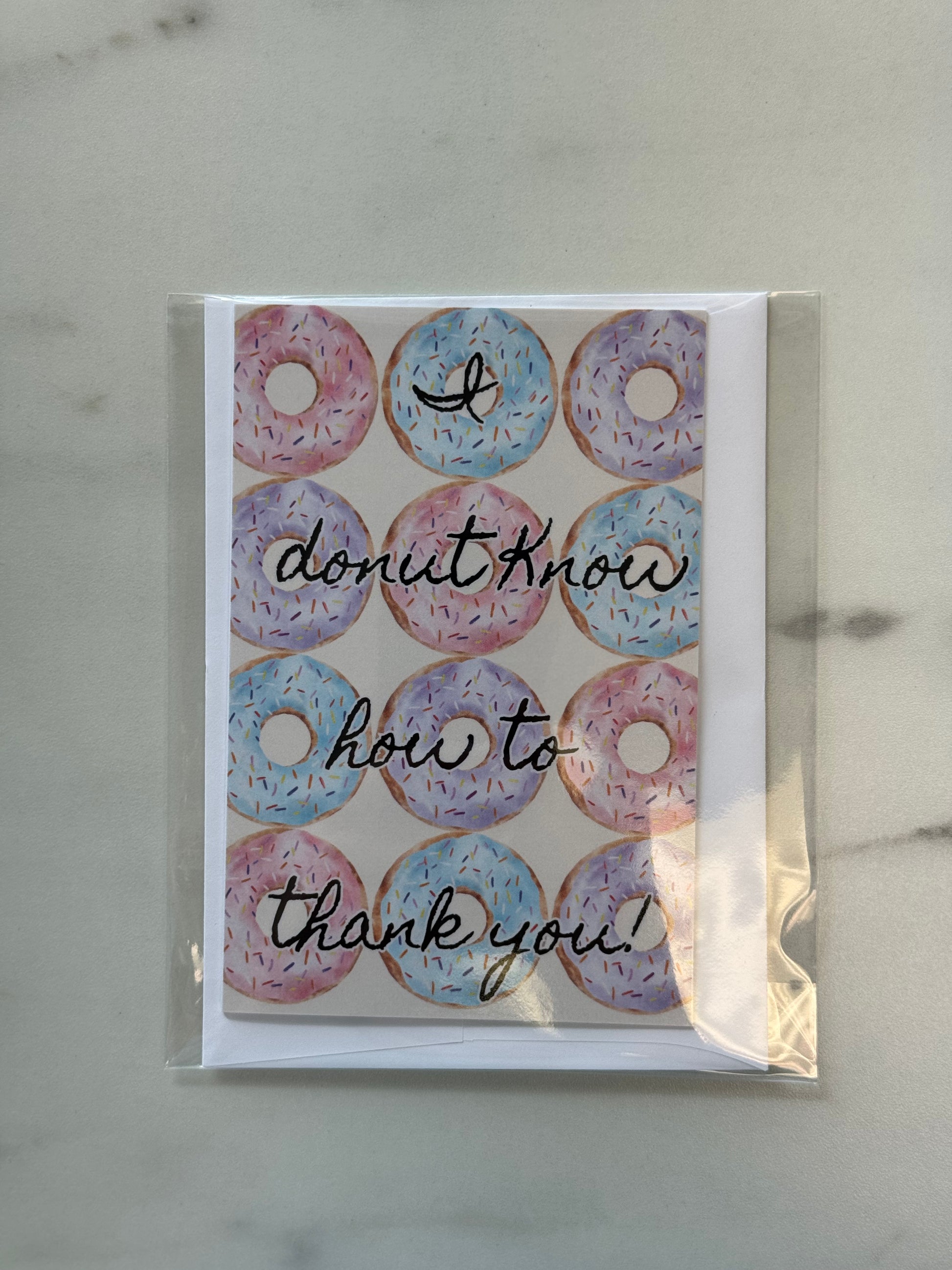 Greeting card with donut design and text on a marble surface