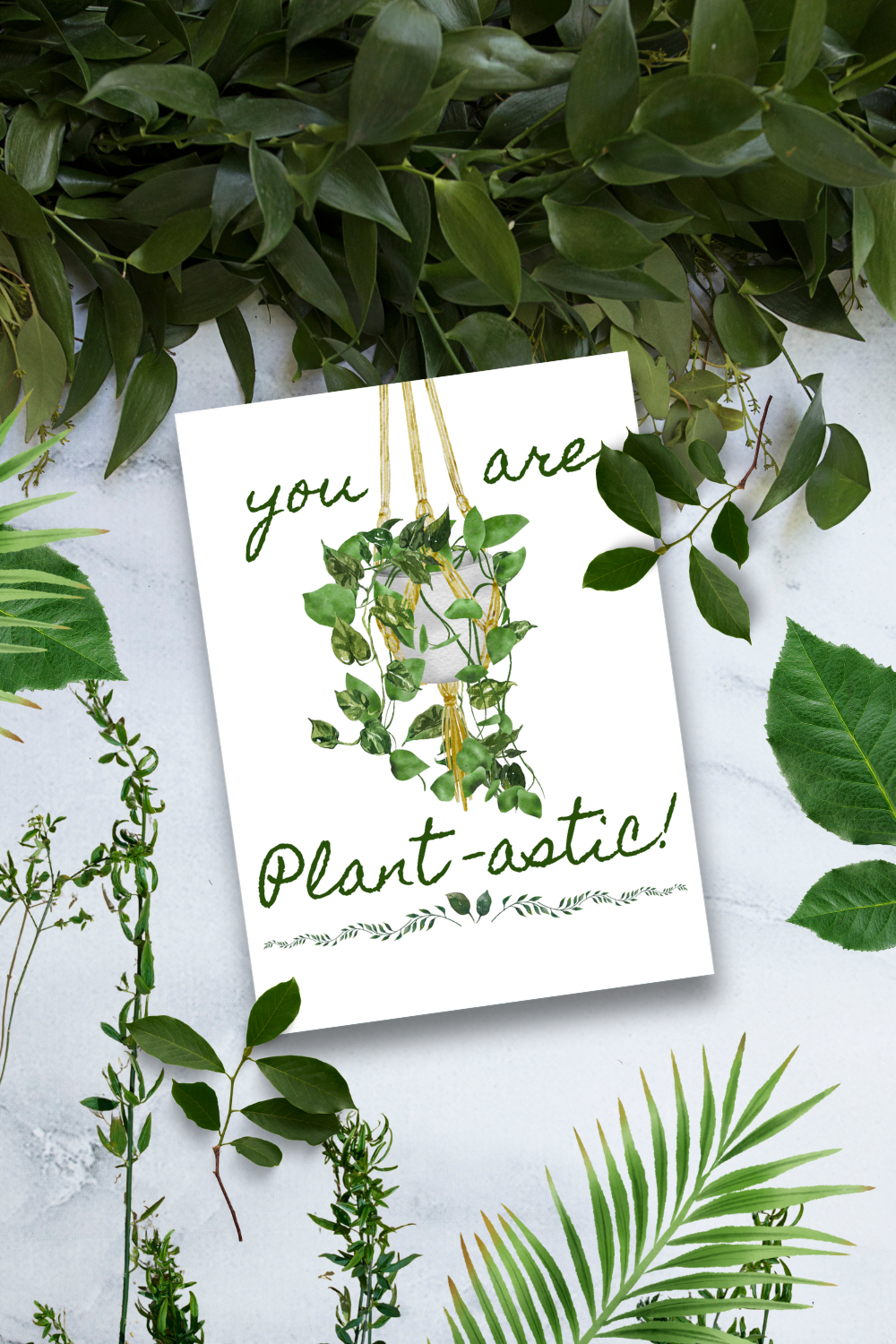 Card with 'you are plant-astic!' text surrounded by green leaves on a light background