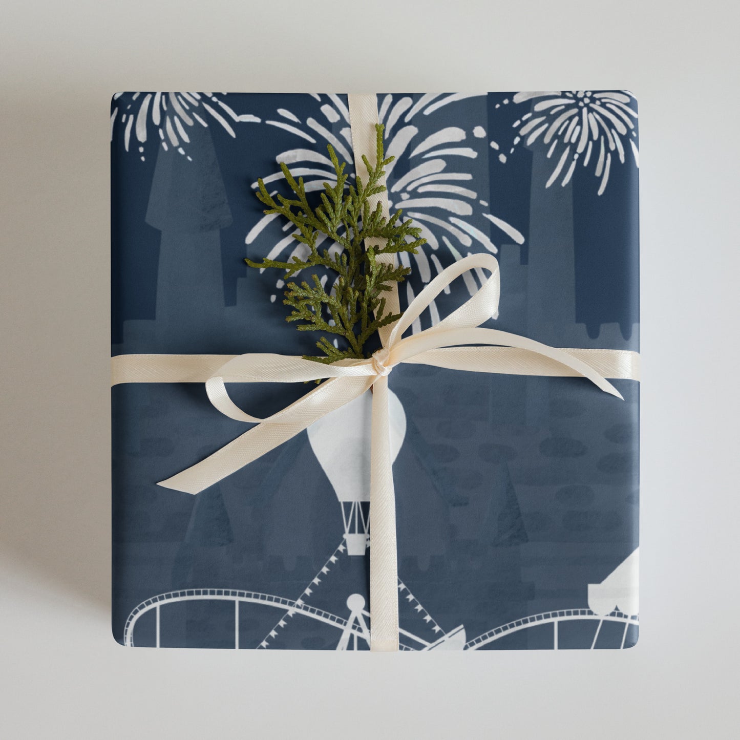 Gift wrapped in blue paper with white patterns and a white ribbon, on a light gray background.