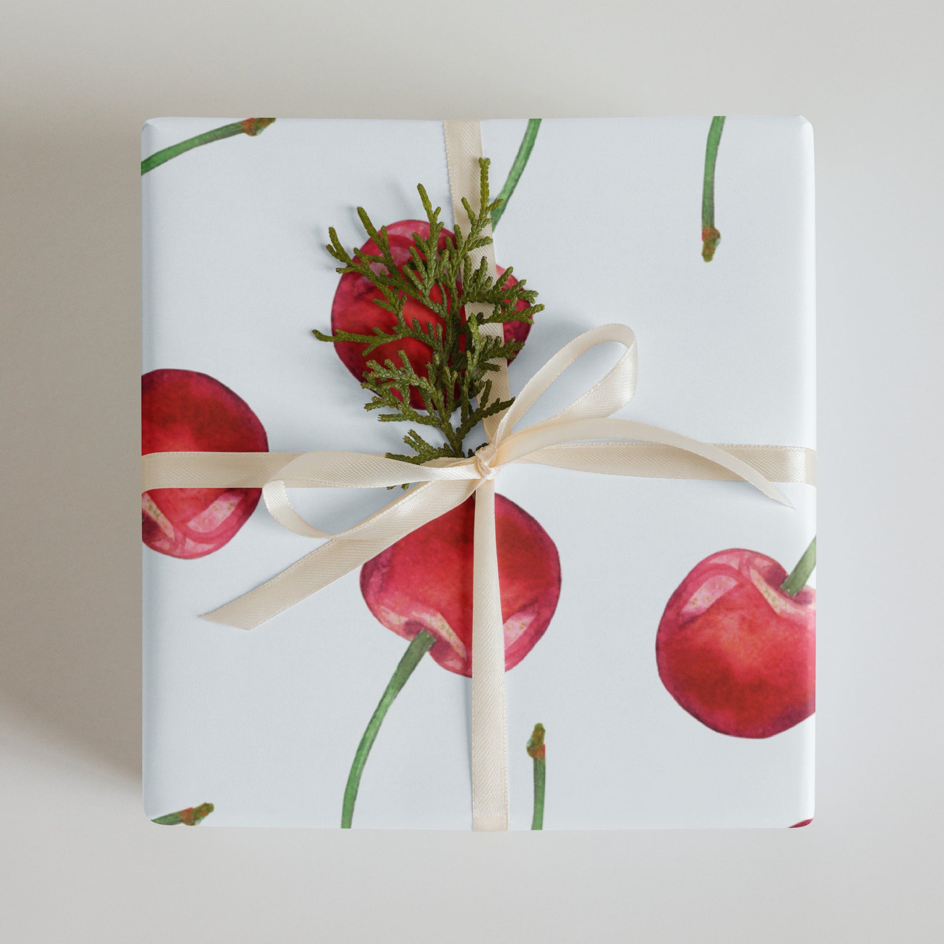 Gift wrapped in paper with red cherry design and a cream ribbon.