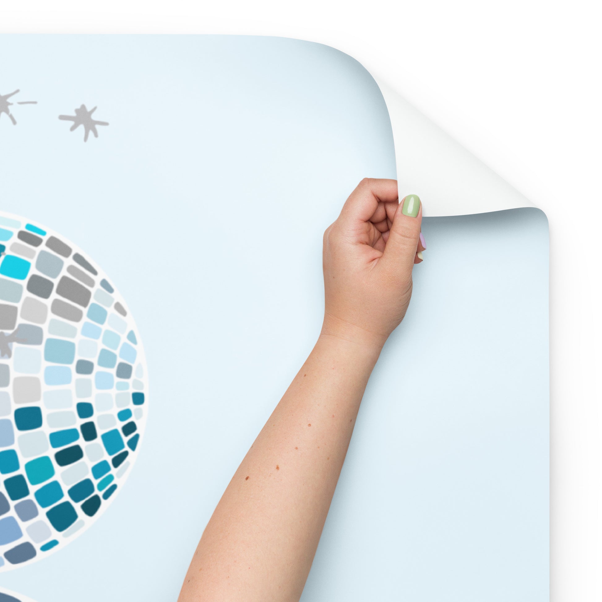 Hand holding a piece of light blue vinyl with a star pattern on a white background