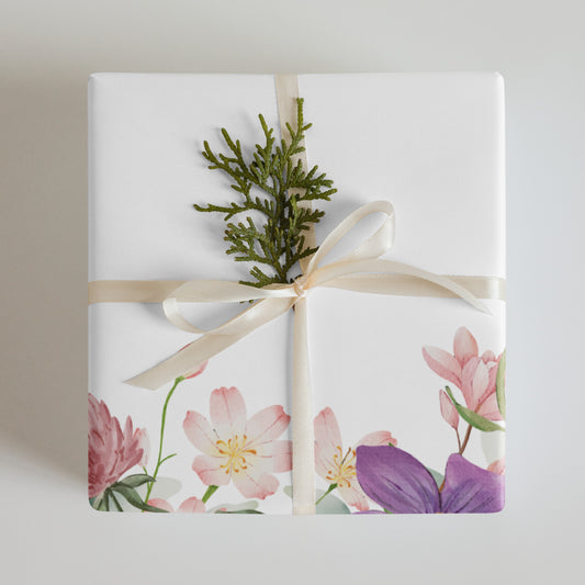 Gift wrapped in floral paper with a green branch and beige ribbon on a light background