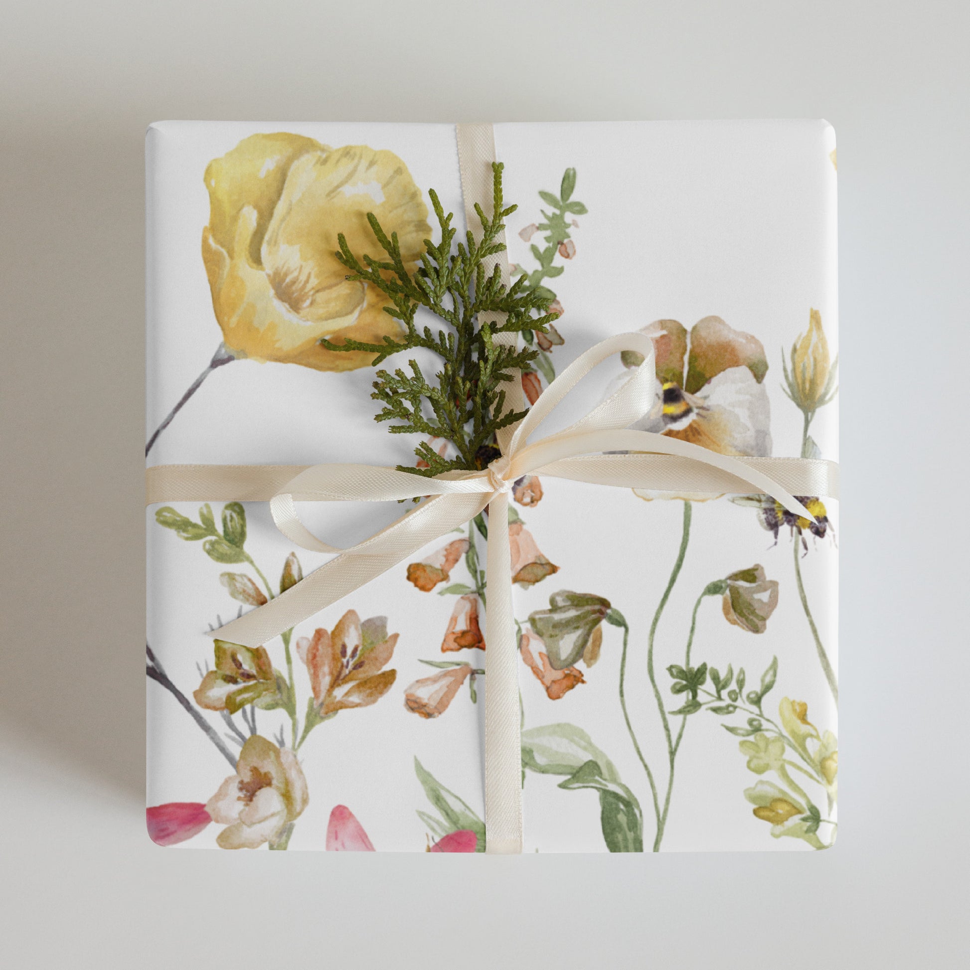 Gift wrapped in floral paper with a bow on a light background