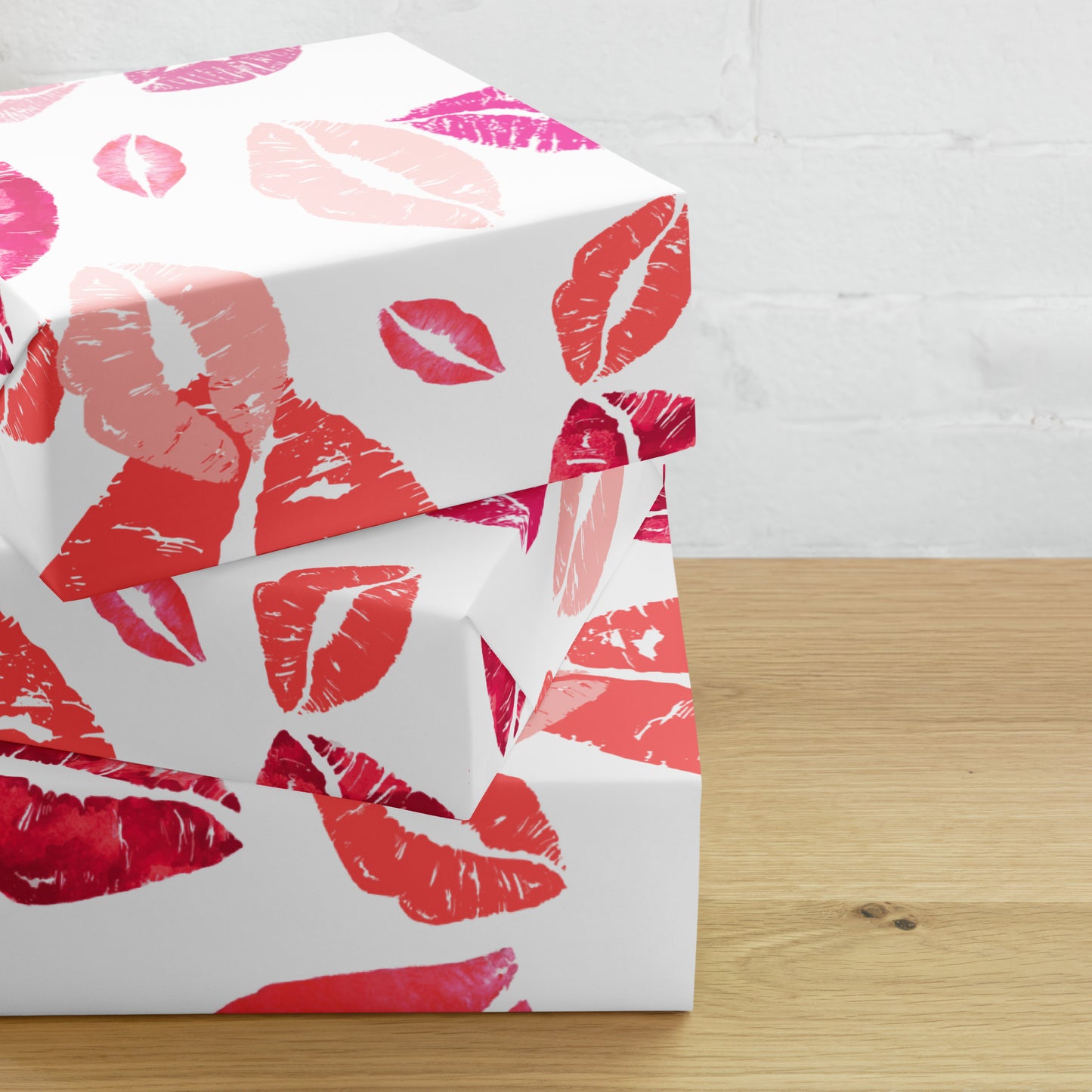 White box with red and pink lip print pattern on a wooden surface.
