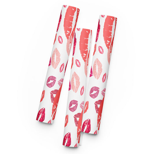 Three white paper rolls with red and pink lip print pattern on a white background