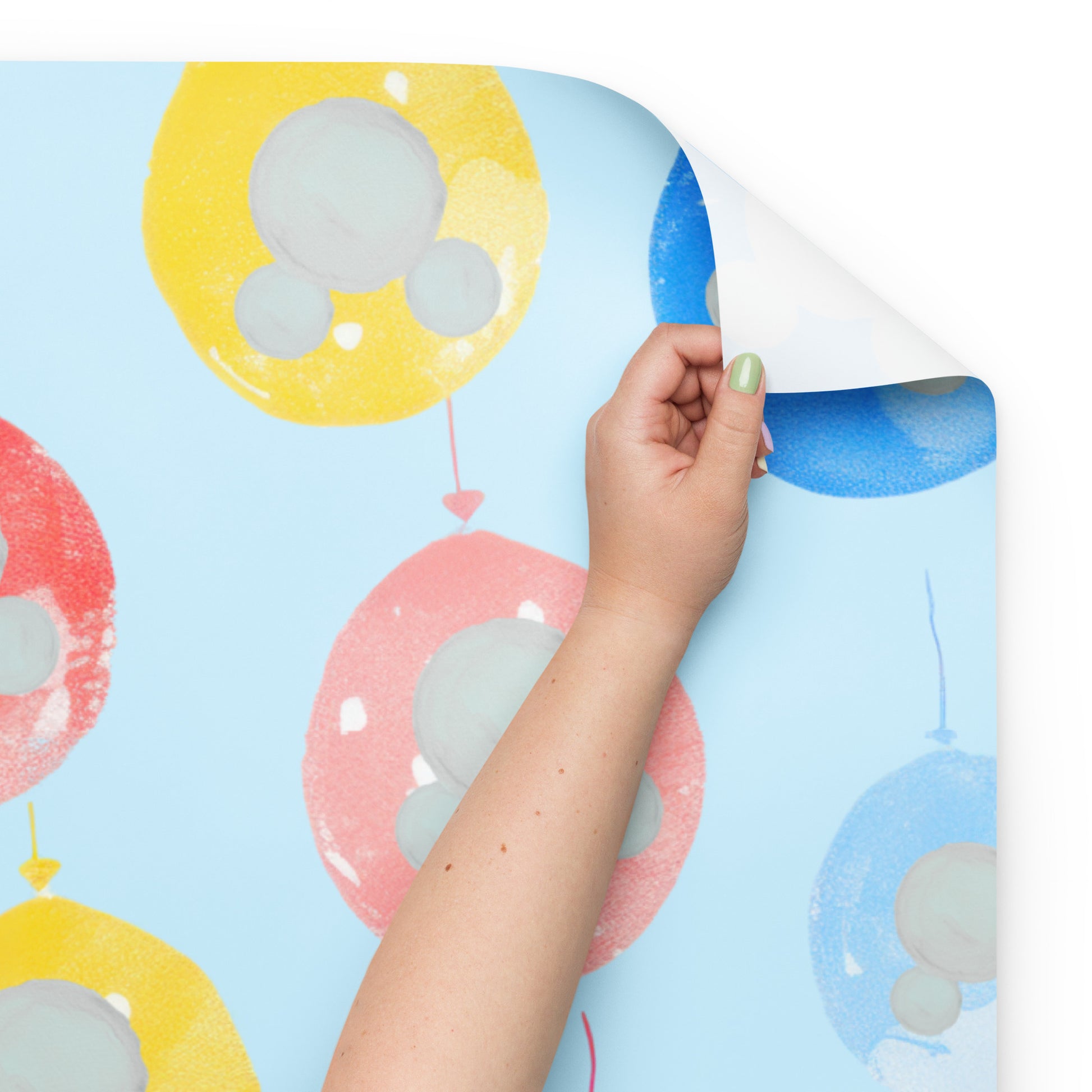 Colorful balloon-themed product with a hand lifting a corner