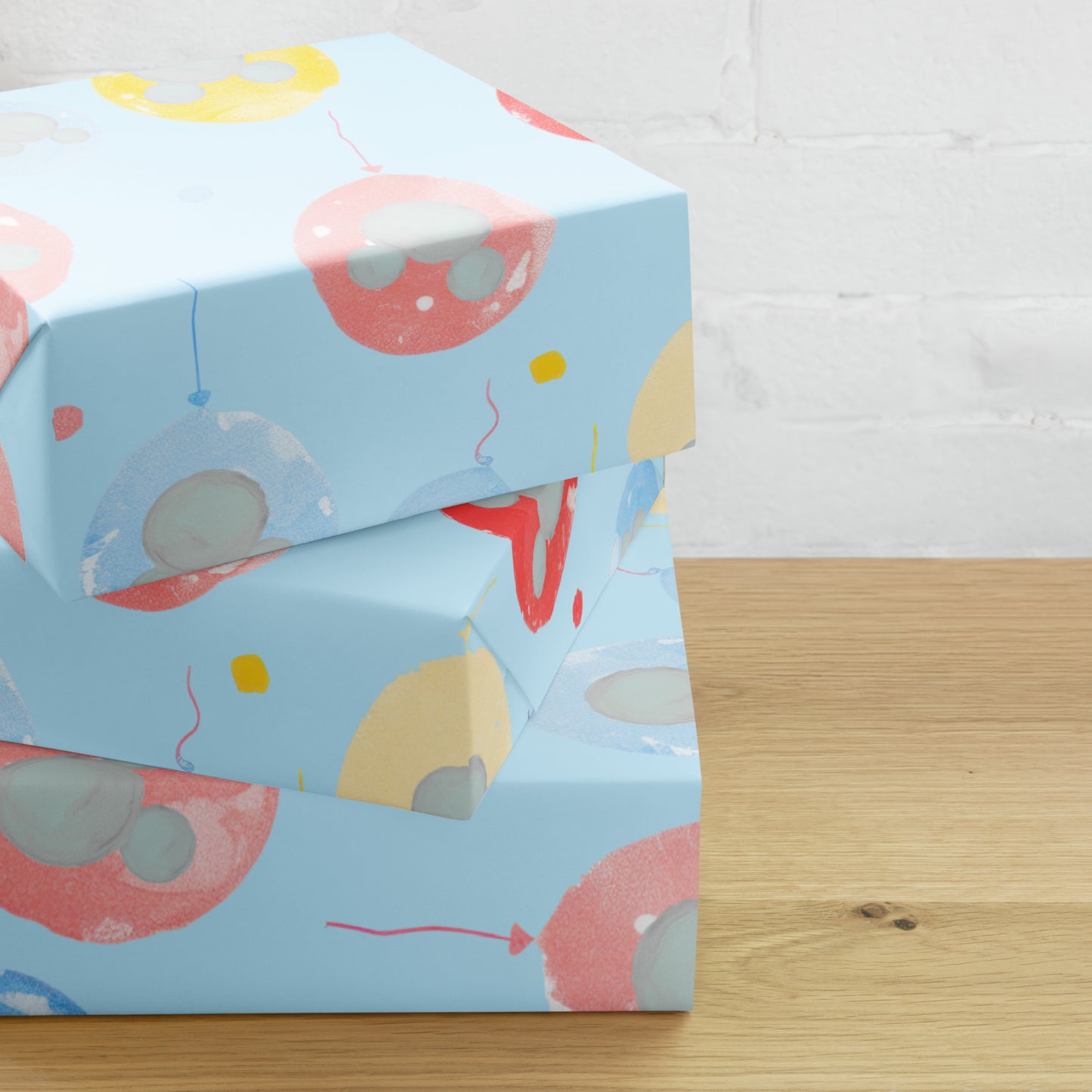 Blue gift box with colorful balloon design on a wooden surface
