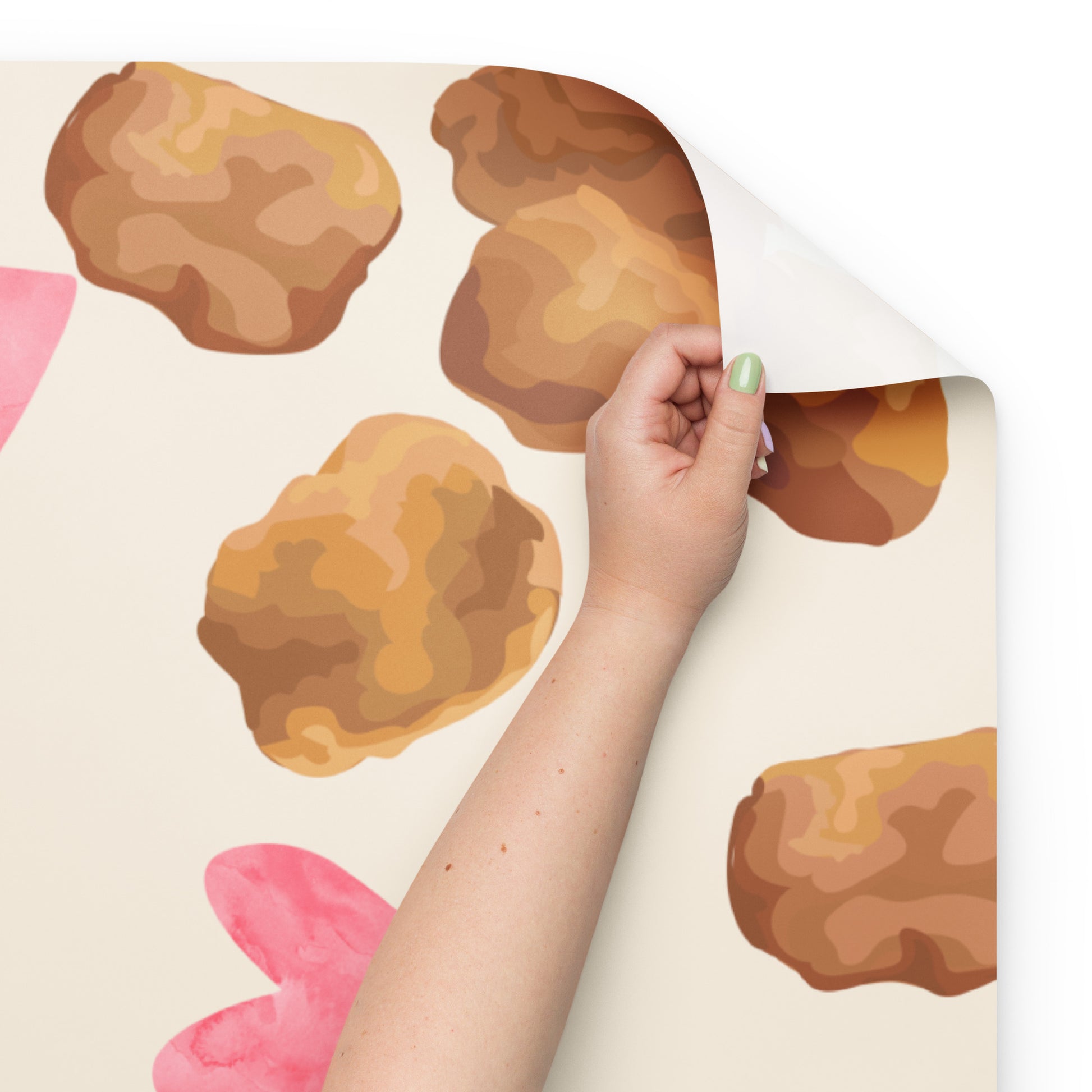 Hand peeling back a decorative paper sheet with brown rock-like patterns on a white background.