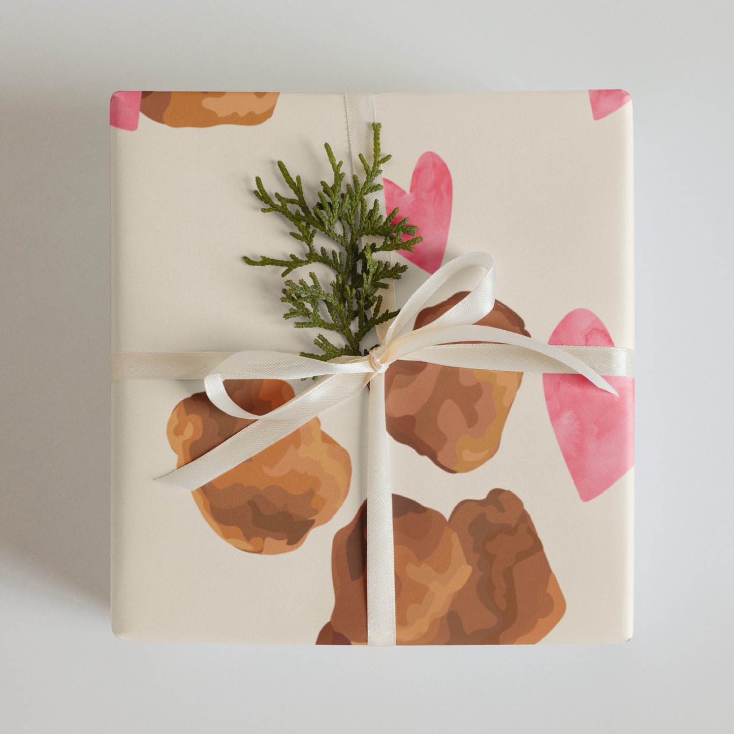 Gift wrapped in paper with chicken nugget and pink hearts, tied with a white ribbon.