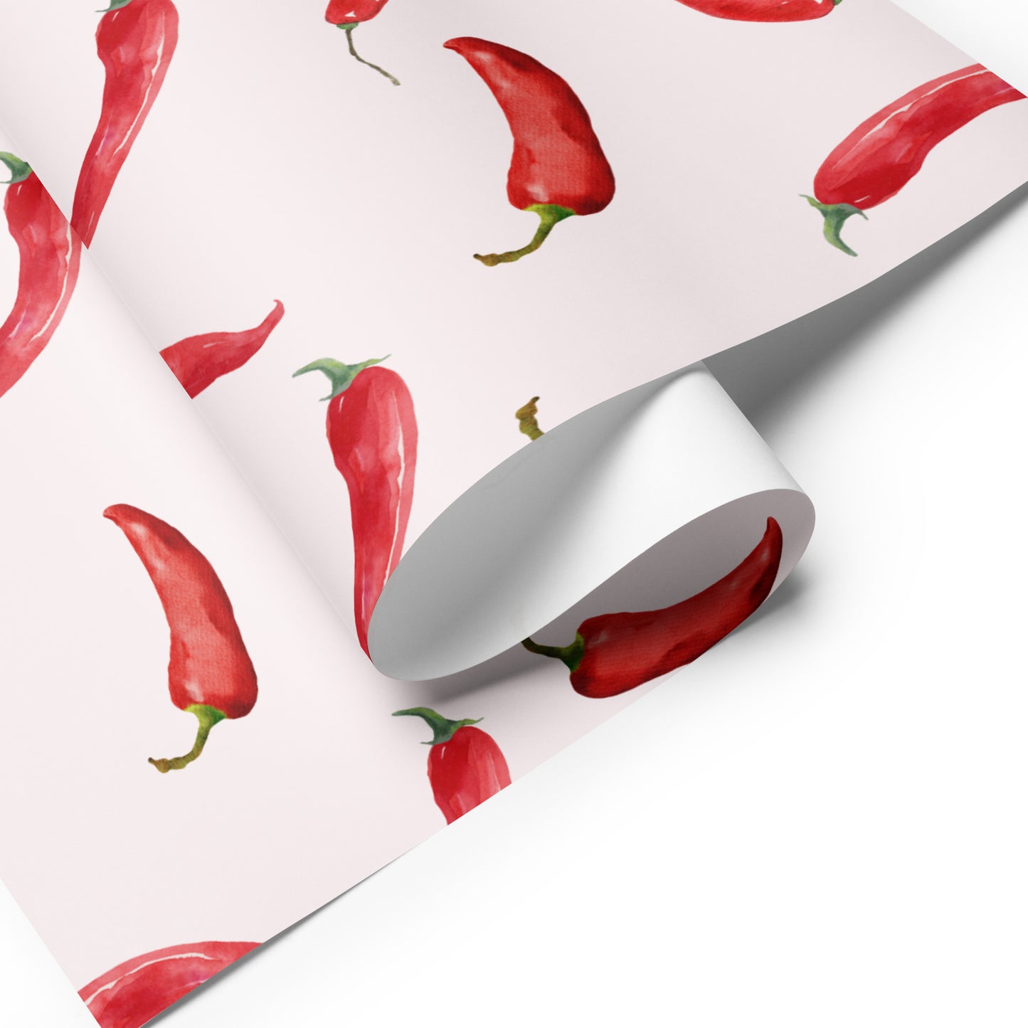 Roll of wrapping paper with red chili pepper pattern on a white background