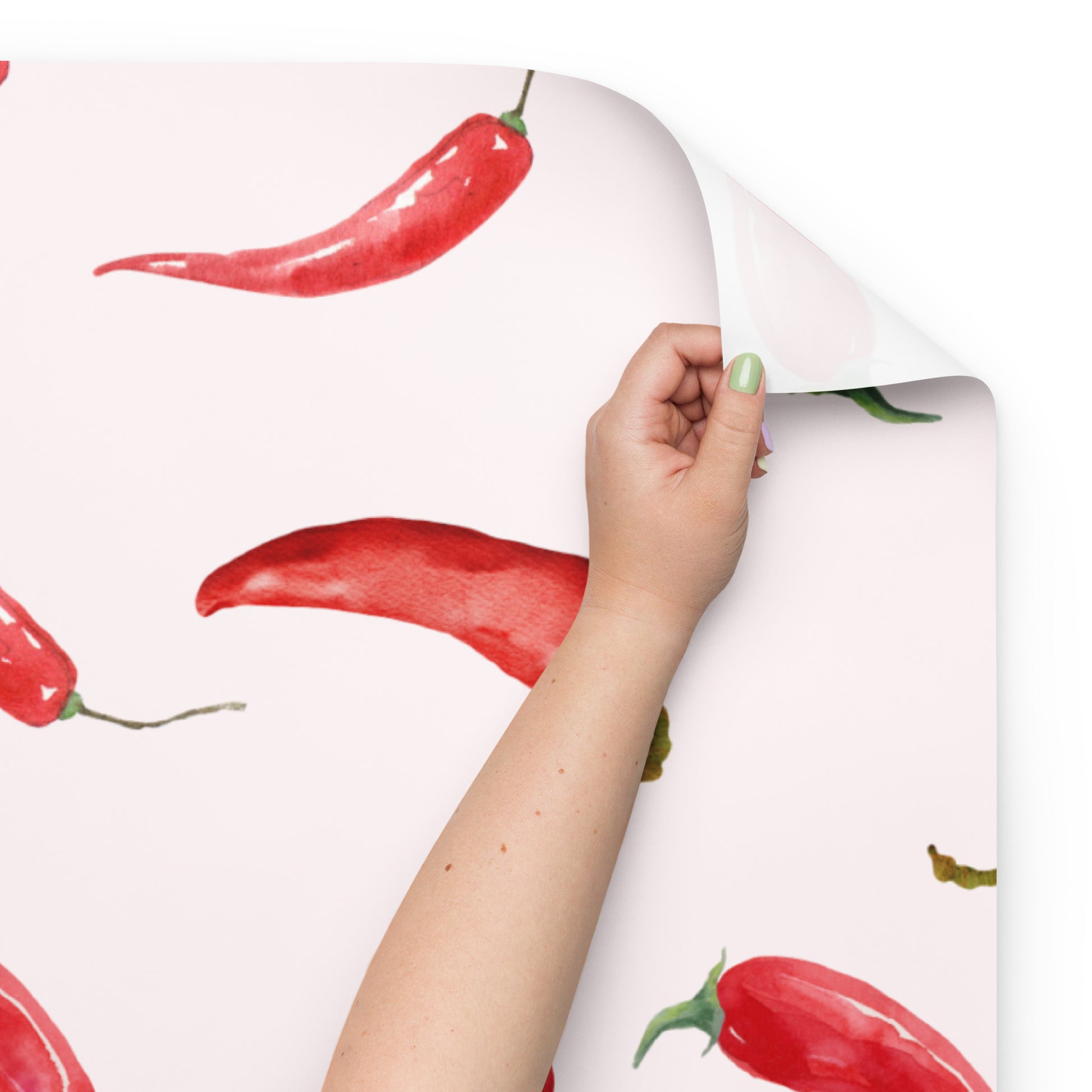 Hand holding a sheet of paper with red chili pepper pattern