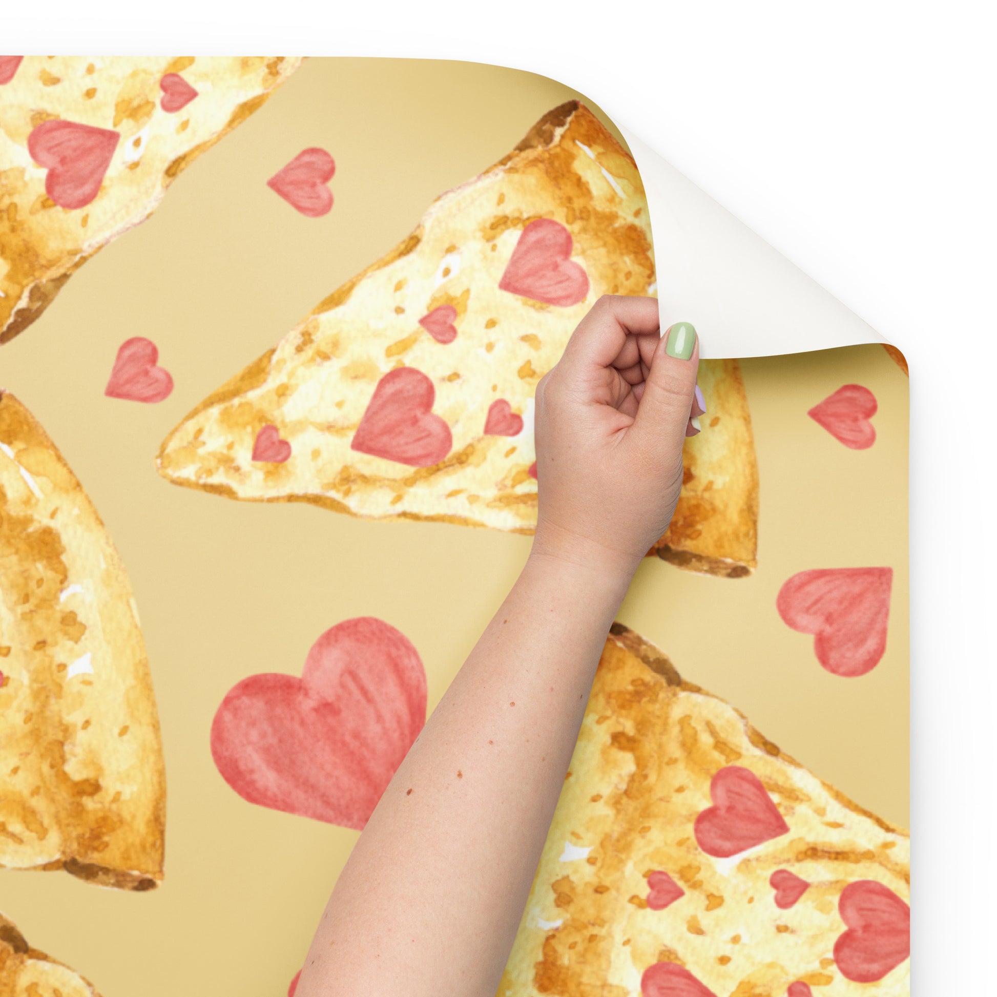 Hand holding a pizza with heart-shaped decorations on a yellow background