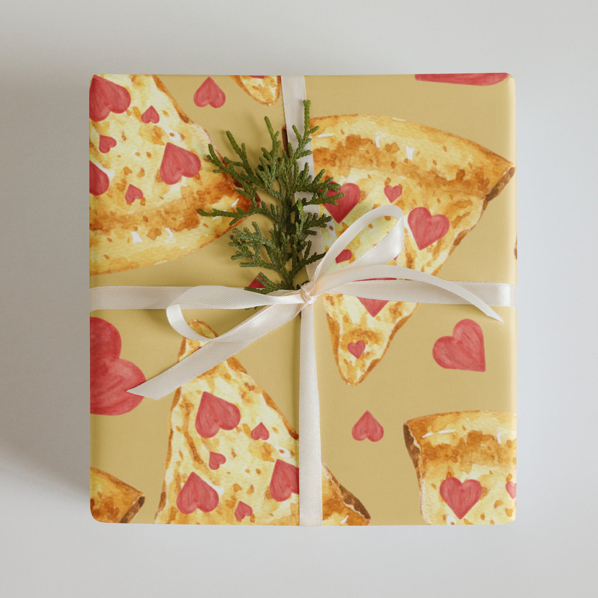 Gift box wrapped with pizza-themed paper featuring heart patterns on a plain background