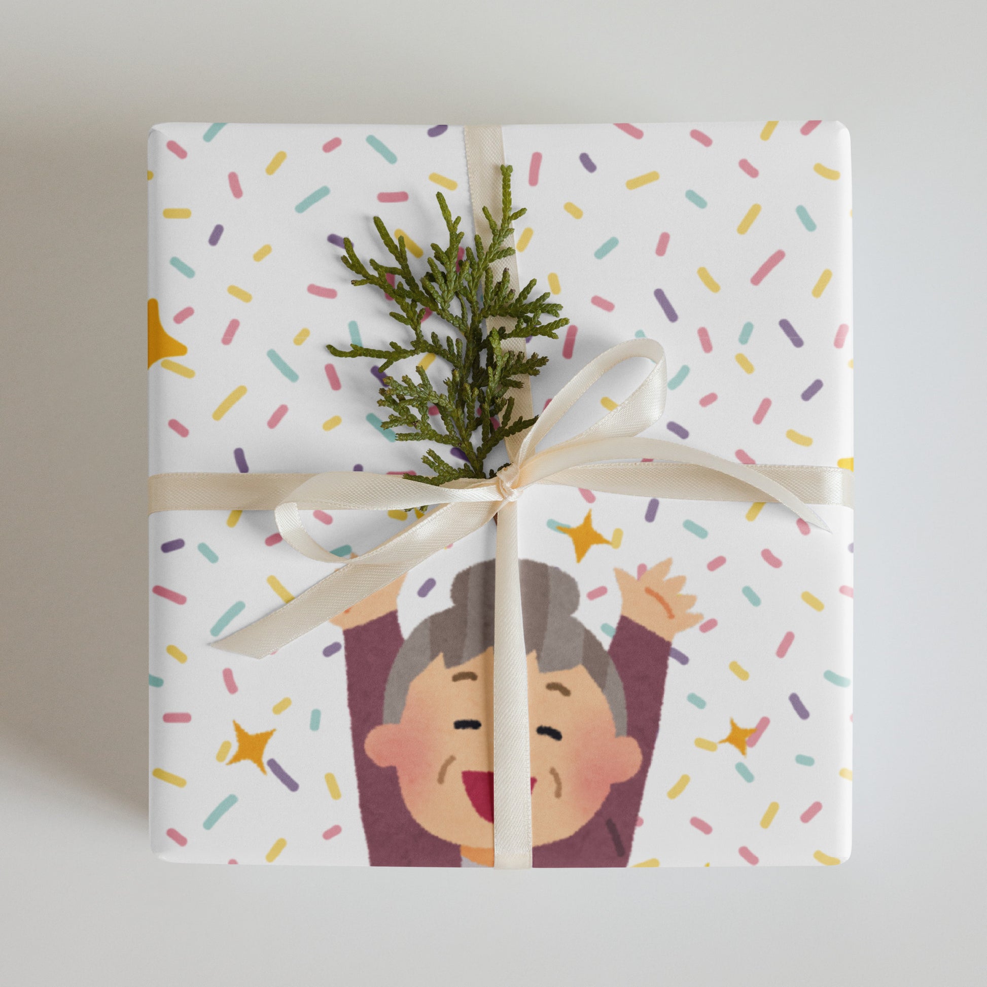 Gift wrapped in colorful paper with a cartoon character and greenery on a light background